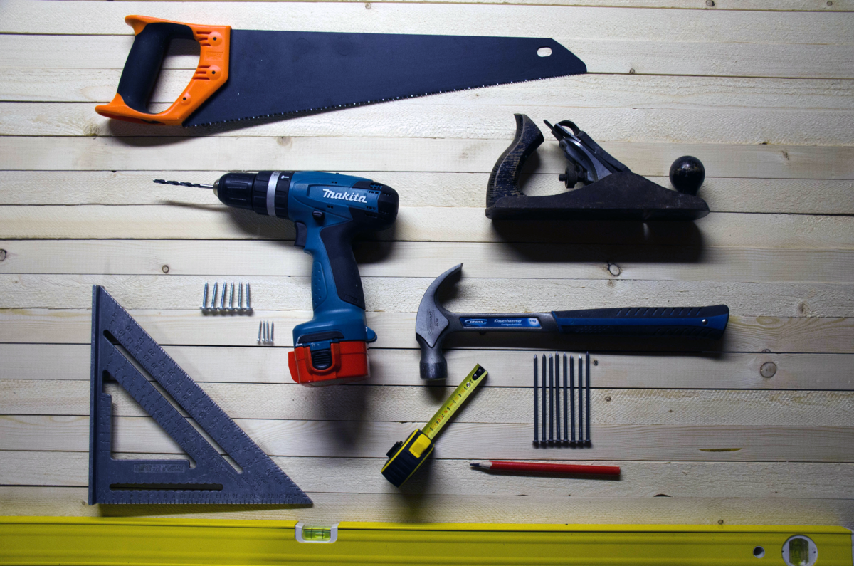 Photo of tools including a drill, saw, and level by Eugen Str on Unsplash